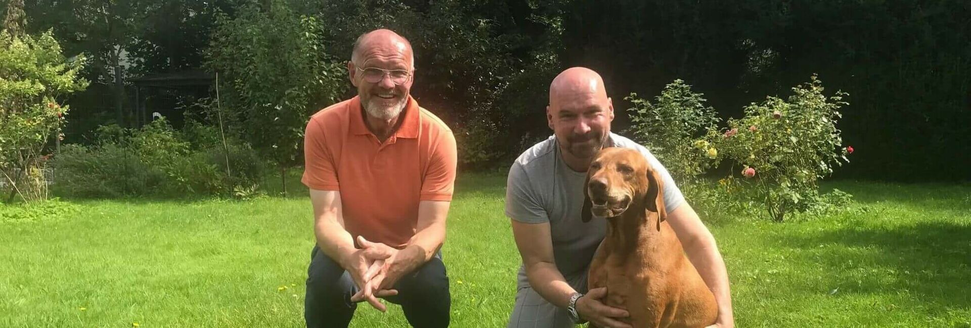 Gastgeber mit einem zu betreuenden Mann mit Hund im Garten auf der Wiese